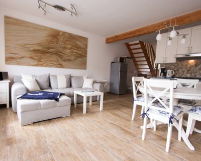 helles Sofa mit kleinem Wohnzimmertisch auf braunen Fliesenboden