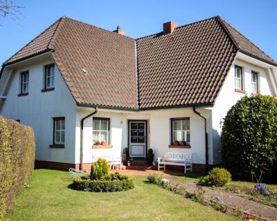 Hauseingang von "Kajari" mit Tür, Garten und Bank.