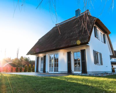 die Rueckansicht zeigt eine große Terrasse im Garten des Ferienhauses